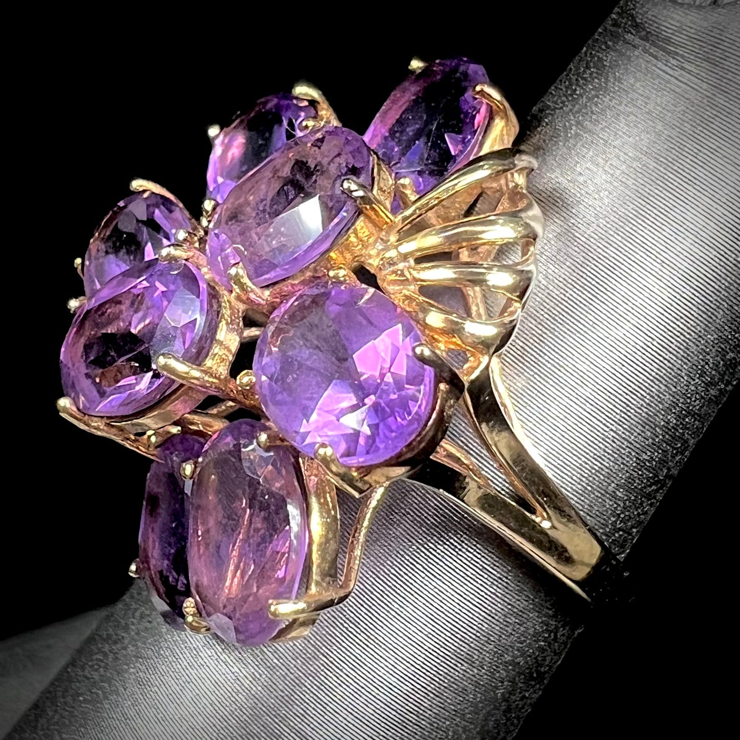 A cluster ring set with eight purple oval cut amethysts in yellow gold.