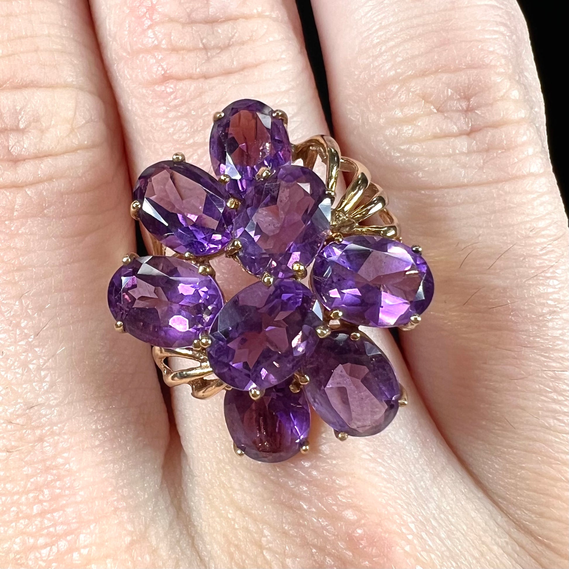 A cluster ring set with eight purple oval cut amethysts in yellow gold.