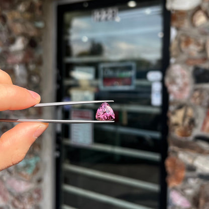 A loose, checkerboard trillion cut purple tourmaline gemstone.