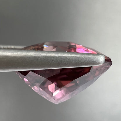 A loose, checkerboard trillion cut purple tourmaline gemstone.