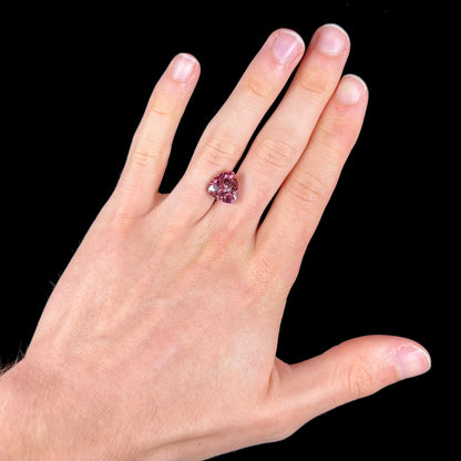 A loose, checkerboard trillion cut purple tourmaline gemstone.