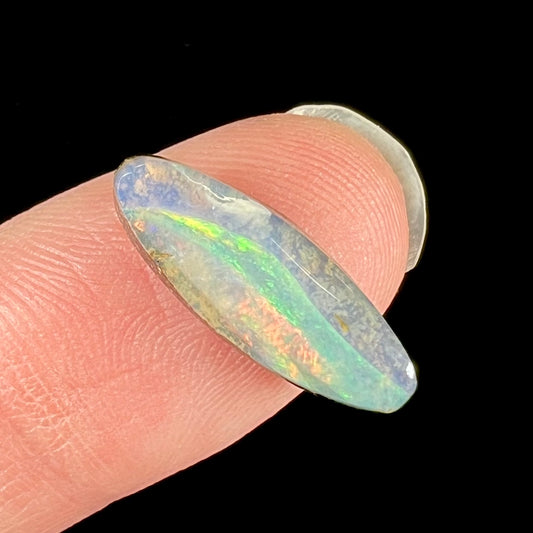 A loose, marquise cut boulder opal from Quilpie, Australia.  The opal has green and red wave patterns.