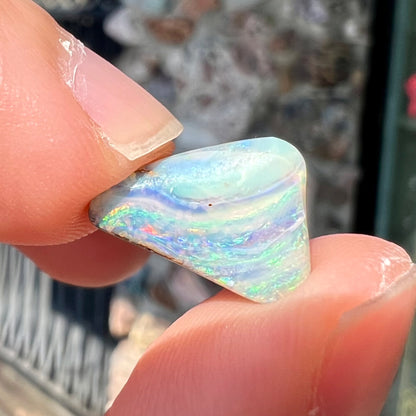 A loose, freeform boulder opal stone from Quilpie, Australia.  The opal has a fissure inclusion.