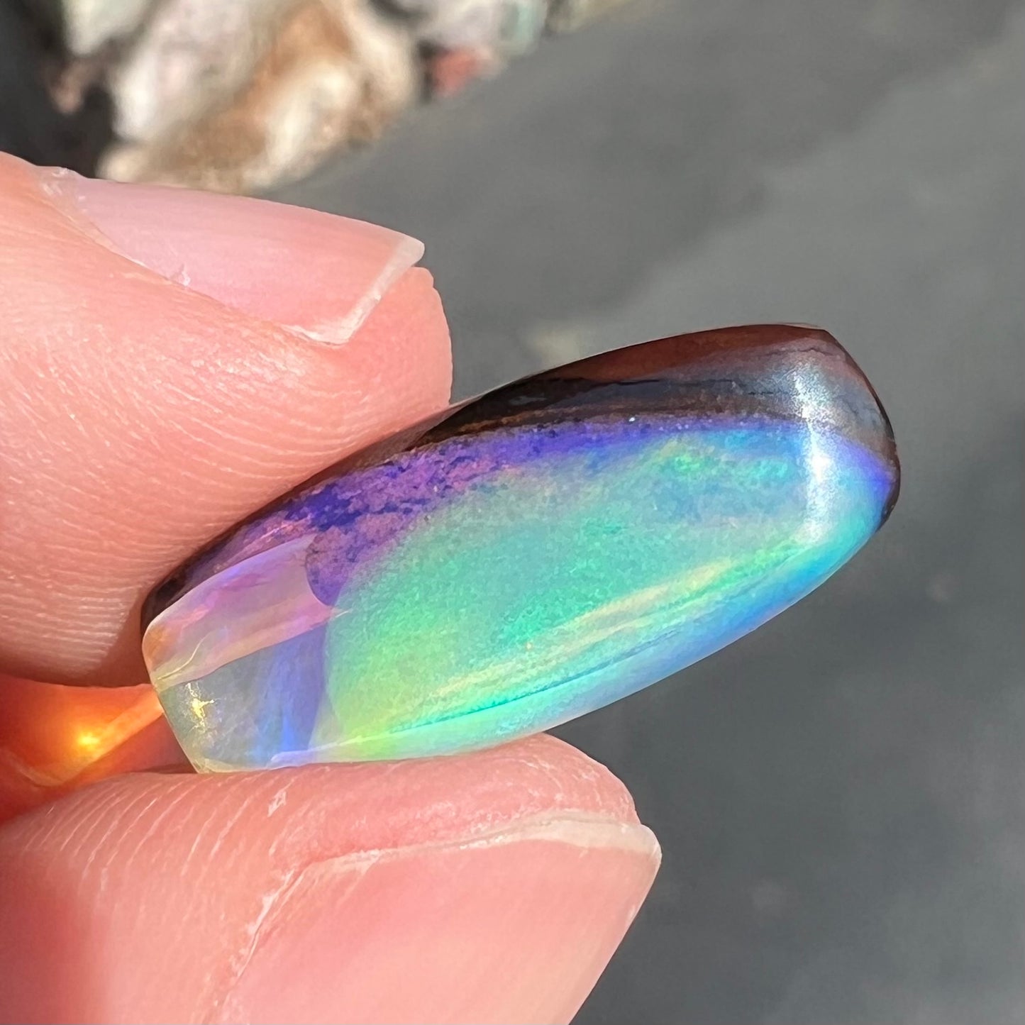 A 6.32ct Brazilian opal stone.  The opal has a green and blue rain pattern.