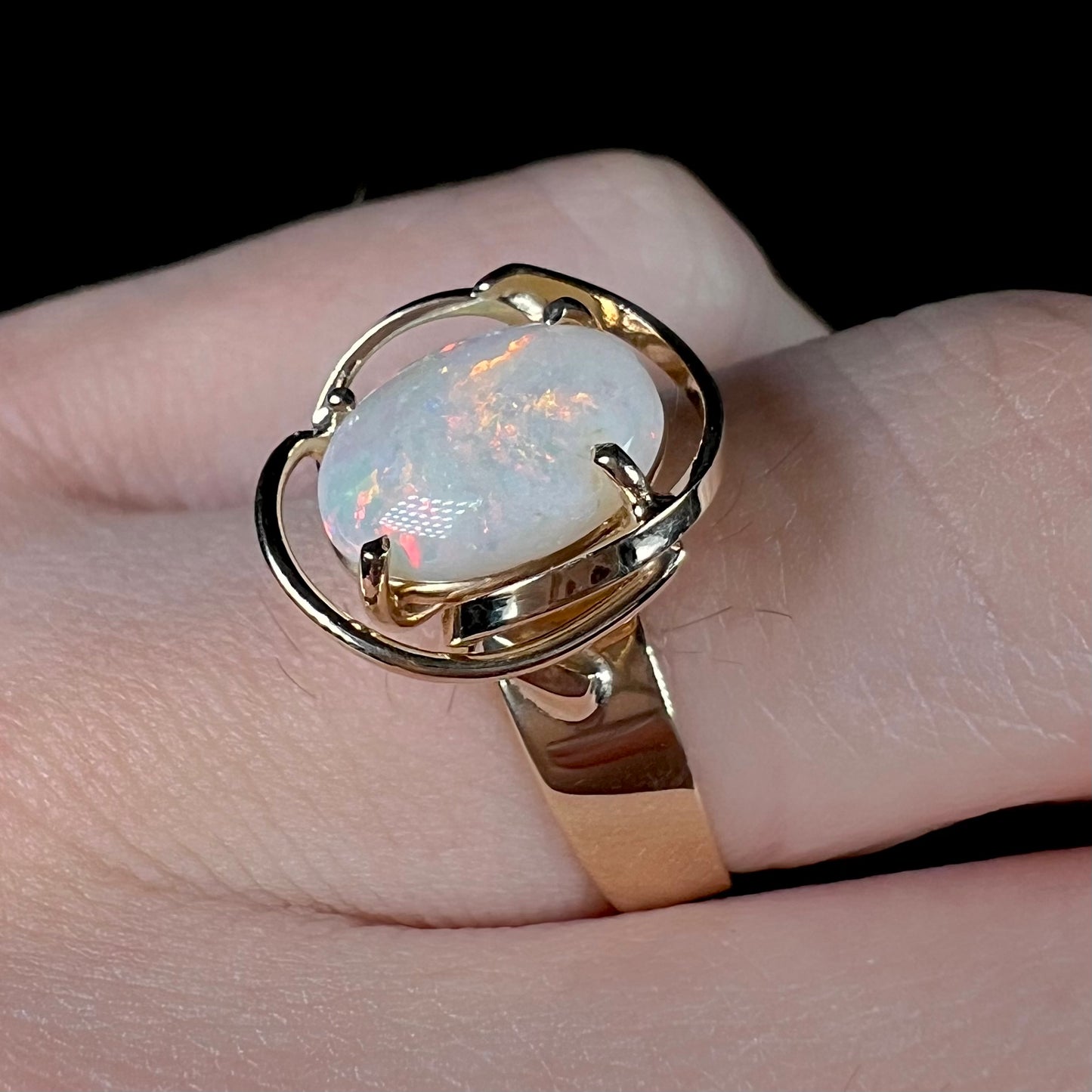 A yellow gold solitaire ring mounted with an oval cut Australian white opal.