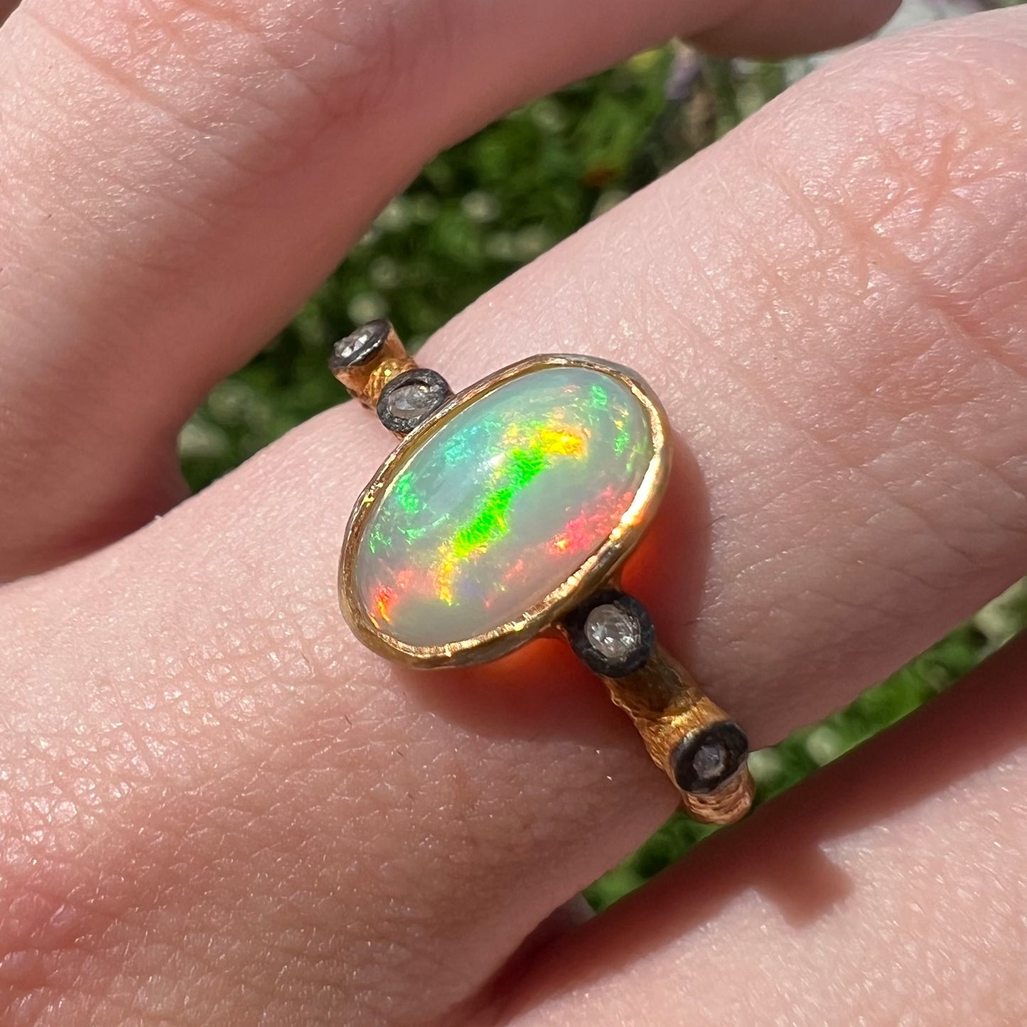 A yellow gold plated sterling silver ring mounted with an Ethiopian fire opal and rose cut diamond accents.