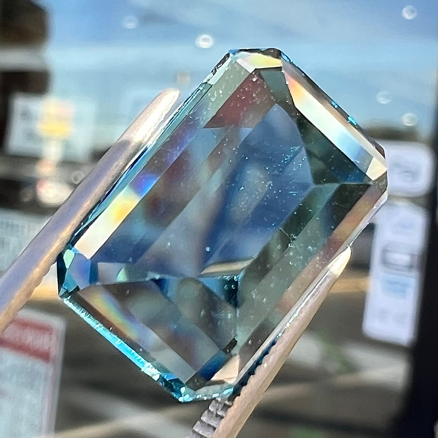 A loose, emerald cut London blue topaz gemstone.  The stone is a deep, dark blue color.