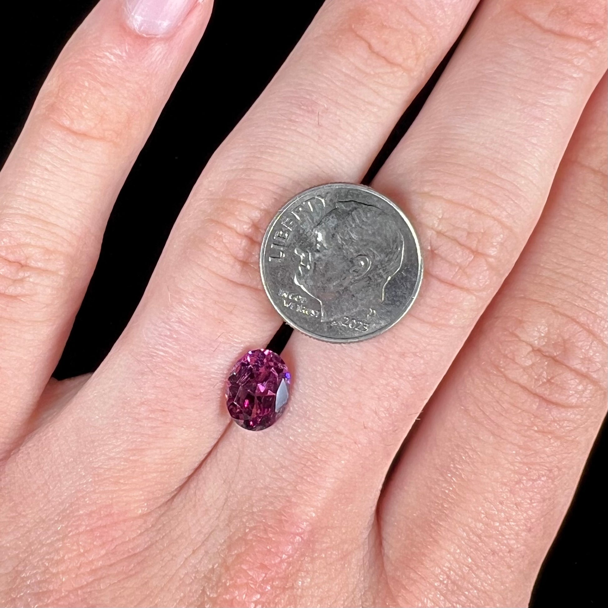 A loose, faceted oval cut purple rhodolite garnet gemstone.