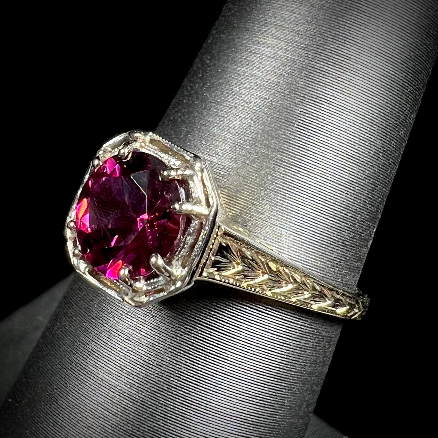 A ladies' yellow gold Art Deco style solitaire ring set with a purple rhodolite garnet gemstone.