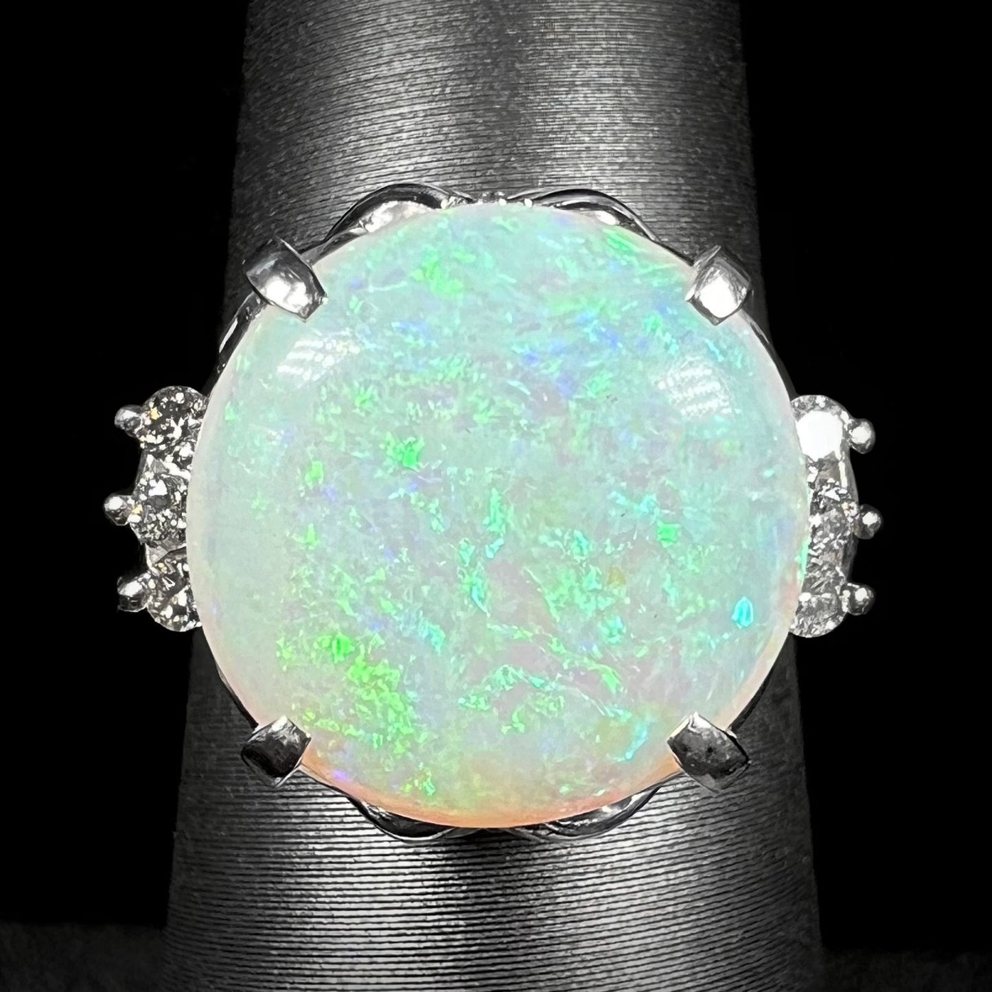 A round cut Australian opal and diamond engagment ring with platinum filigree.