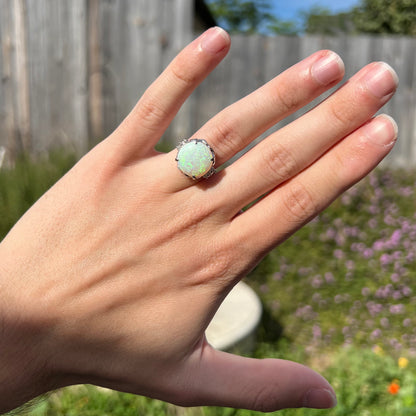 A round cut Australian opal and diamond engagment ring with platinum filigree.