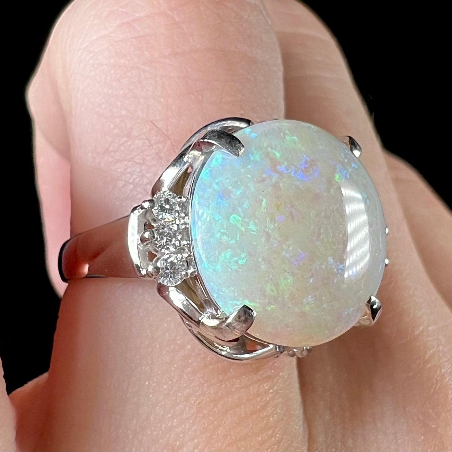 A round cut Australian opal and diamond engagment ring with platinum filigree.