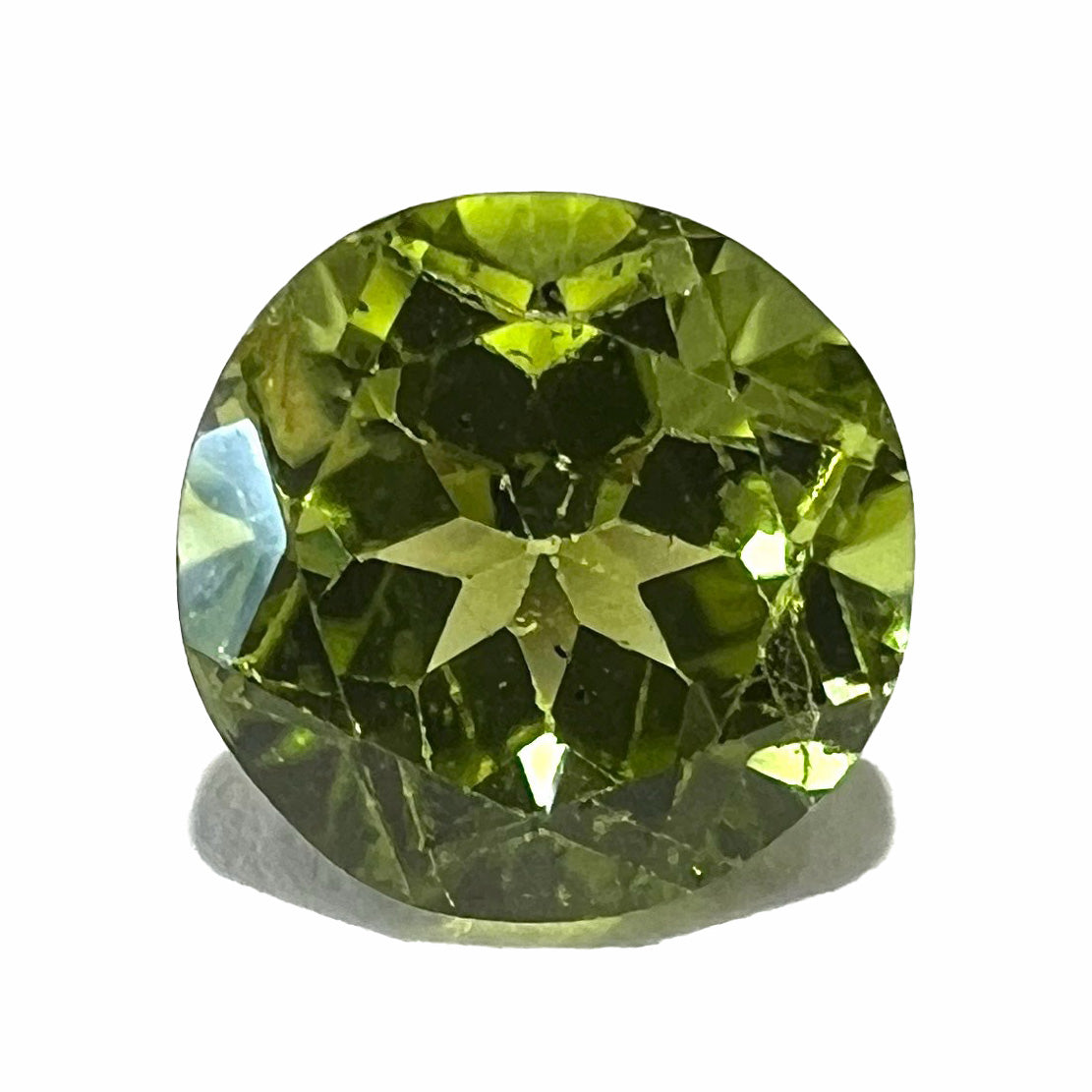 A loose, round brilliant cut peridot gemstone.