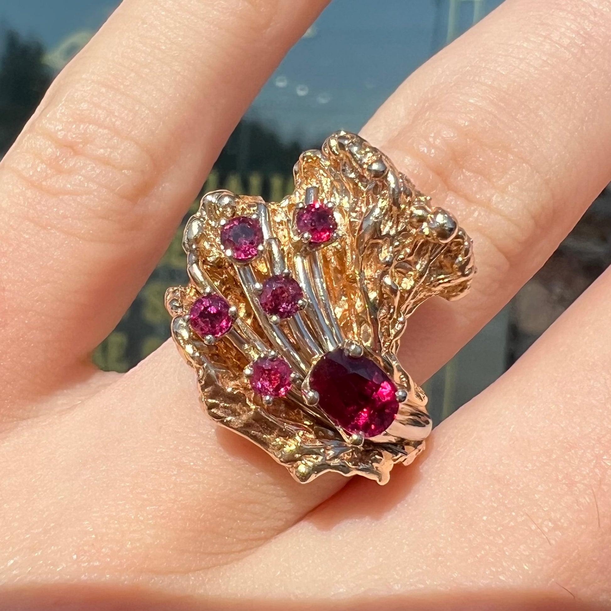 A yellow gold ruby cluster ring from the 1950's.  There is one oval cut ruby and five round cut rubies.