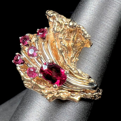 A yellow gold ruby cluster ring from the 1950's.  There is one oval cut ruby and five round cut rubies.