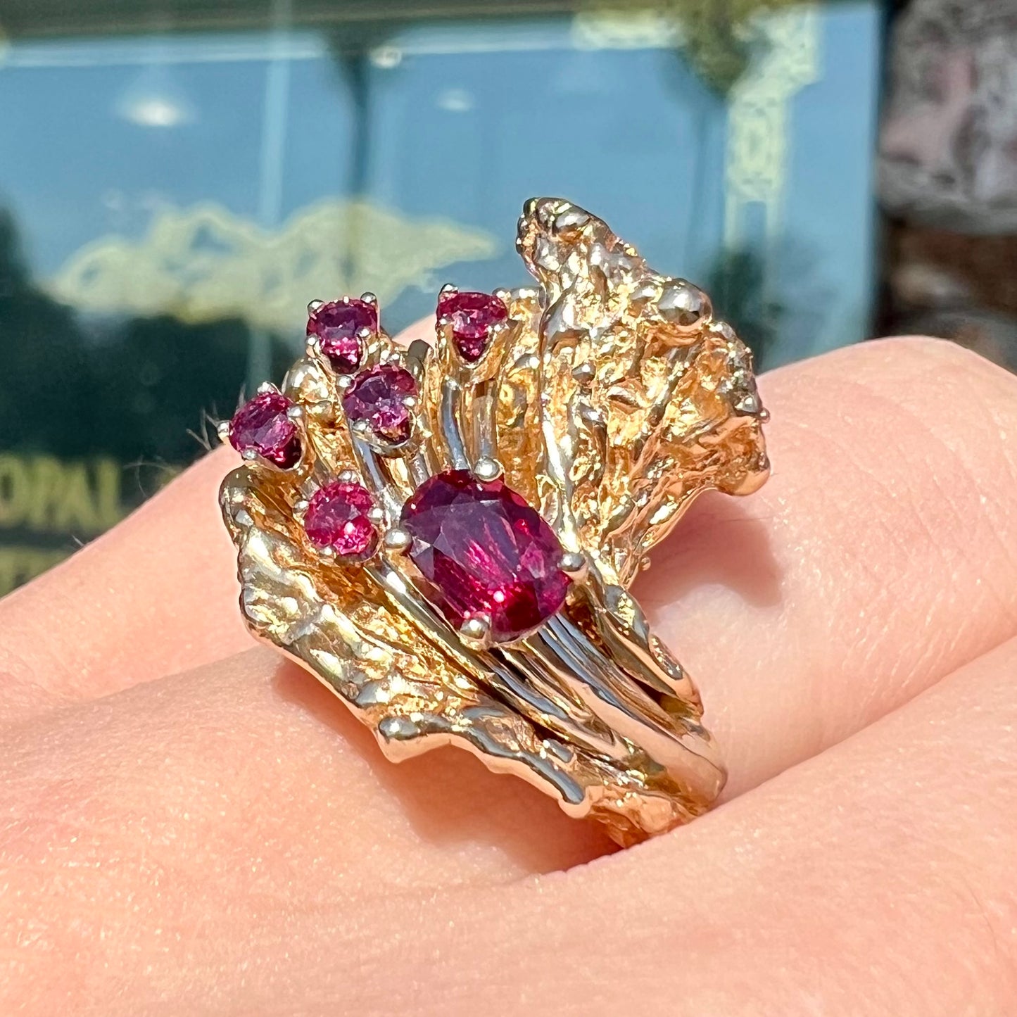 A yellow gold ruby cluster ring from the 1950's.  There is one oval cut ruby and five round cut rubies.