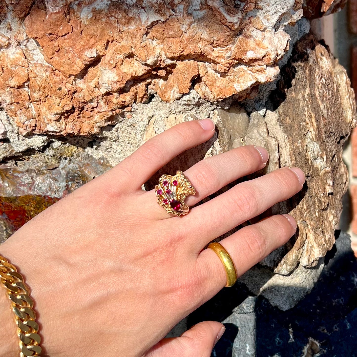 A yellow gold ruby cluster ring from the 1950's.  There is one oval cut ruby and five round cut rubies.