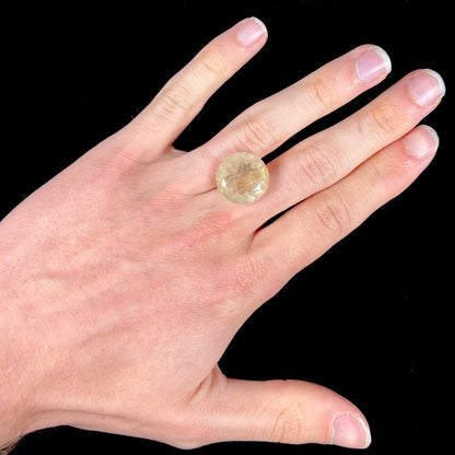 A loose, modified Early American round cut rutilated quartz gemstone.  The rutile inclusions are a golden color.