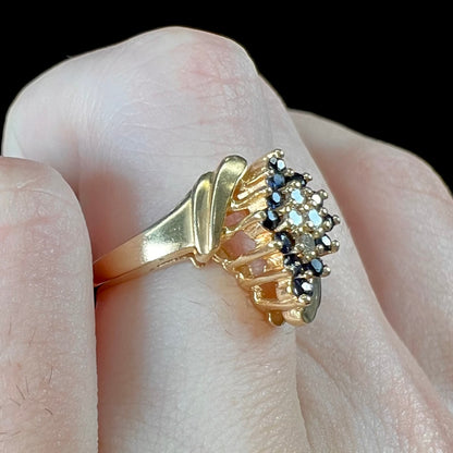 An estate, yellow gold ladies' cluster ring mounted with four round diamonds and twelve round blue sapphires.