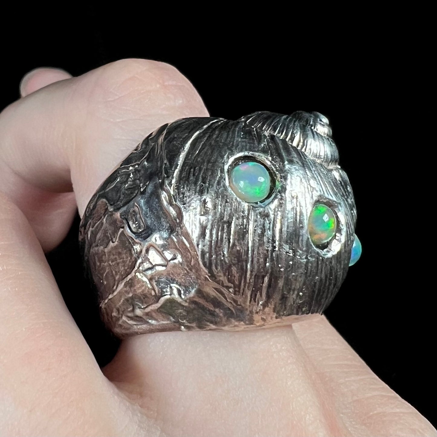 A large, three dimensional sterling silver snail seashell ring set with three round Ethiopian fire opal stones.