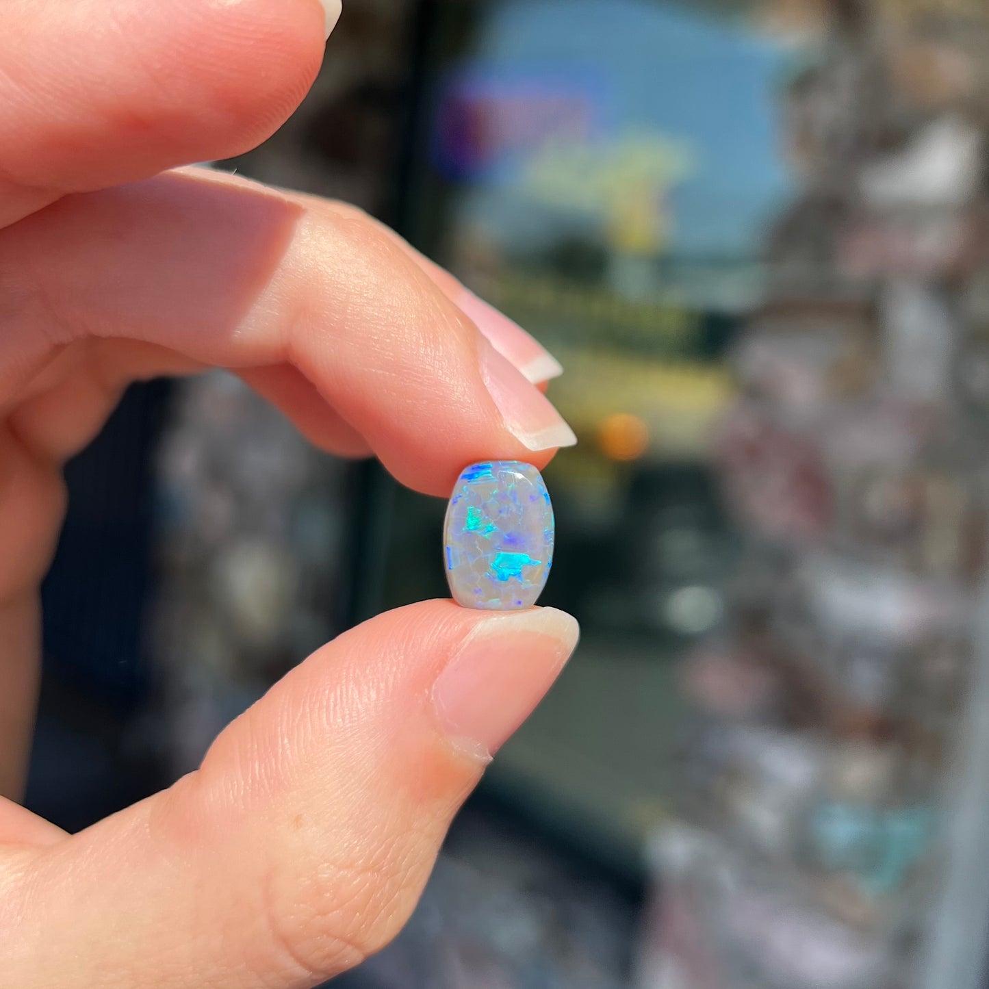 A loose, barrel shaped semi-black opal from Lightning Ridge, Australia.  The opal has blue colors.