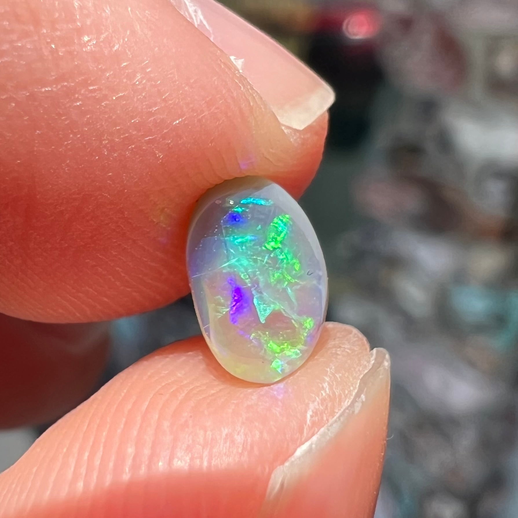 A loose, oval cabochon cut semi-black crystal opal from Lightning Ridge, Australia.