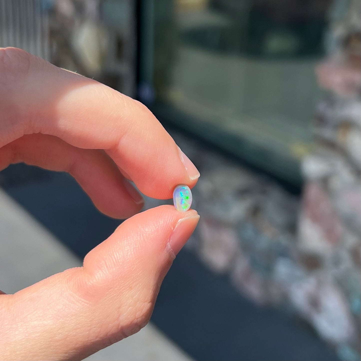 A loose, oval cabochon cut semi-black crystal opal from Lightning Ridge, Australia.