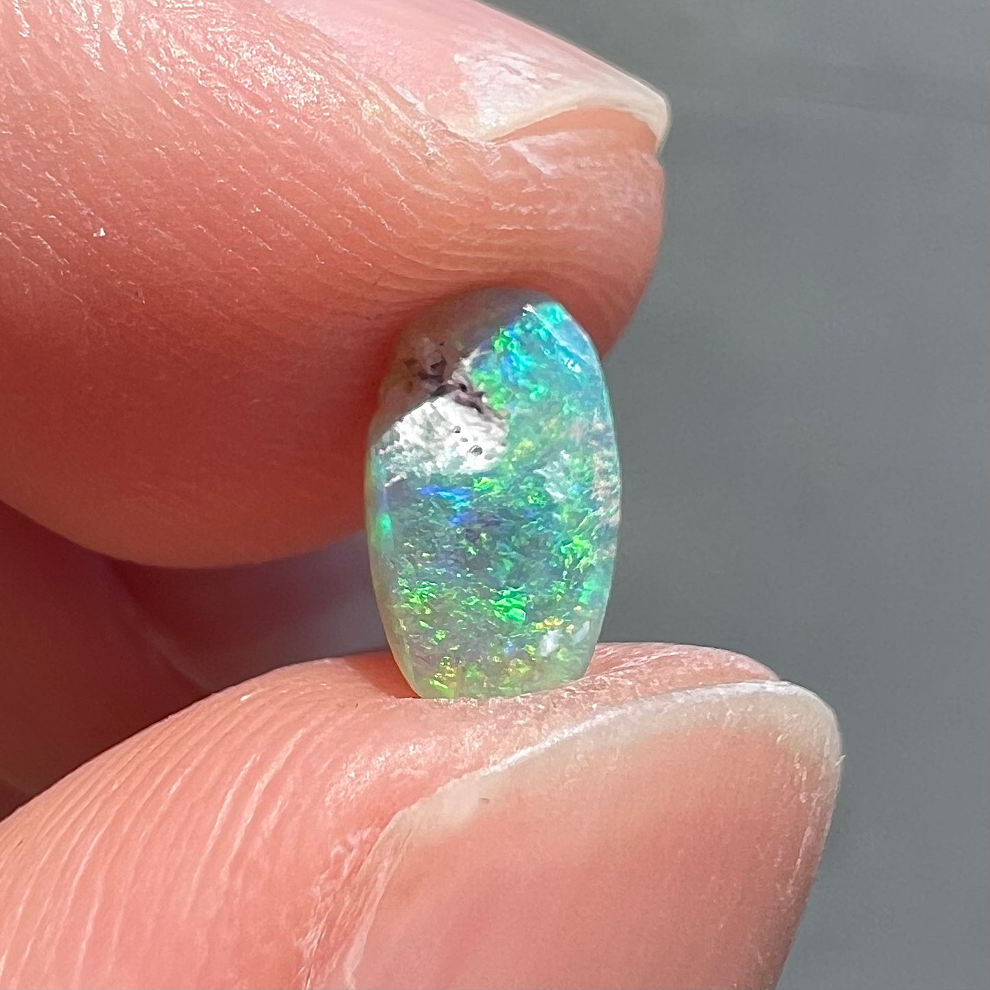 A loose, semi-crystal opal from Australia.  The opal predominantly show green and orange colors.