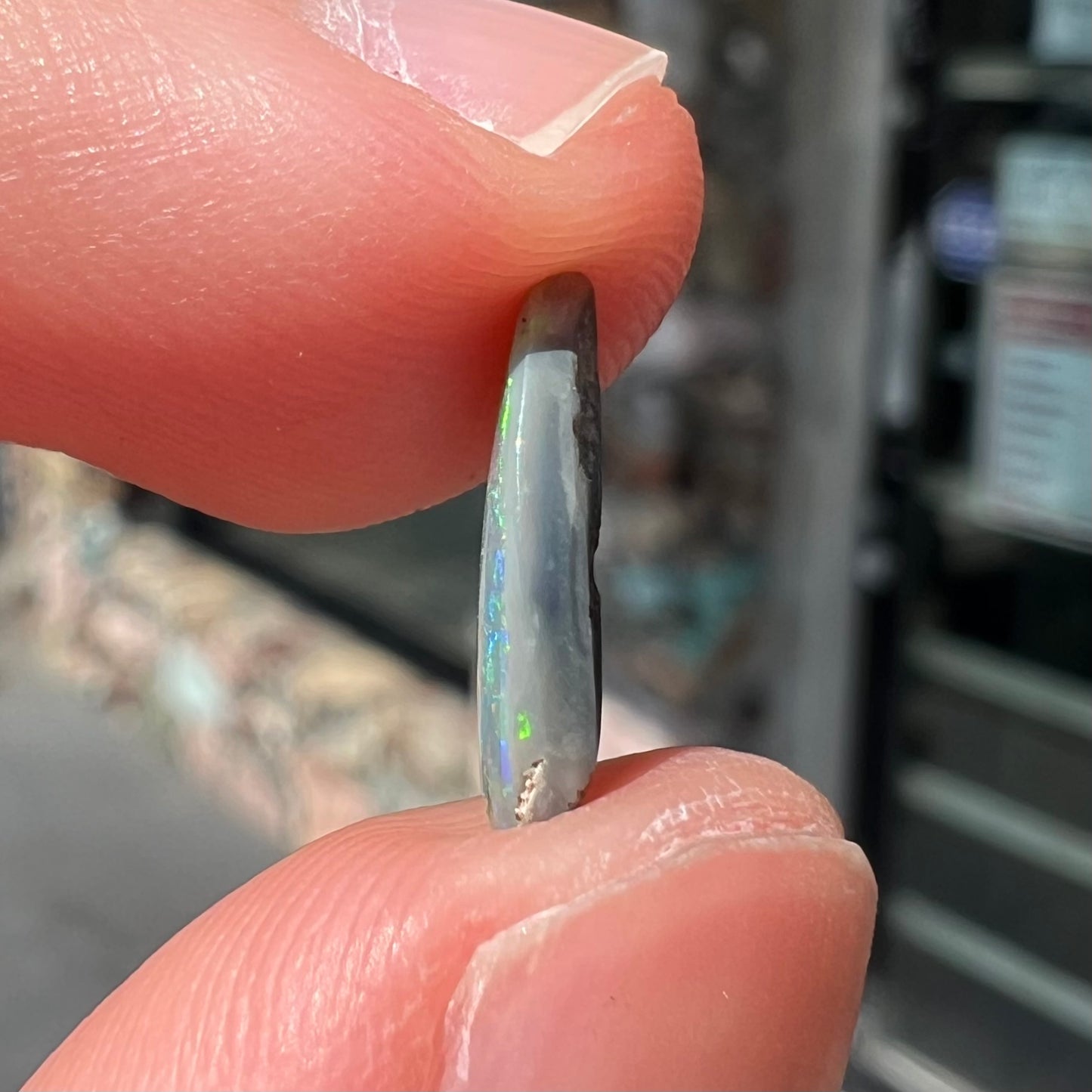 A loose, pear shaped Australian opal stone.  The opal shows green and blue colors.