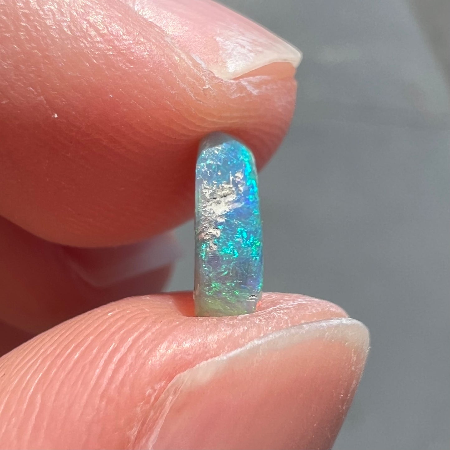 A loose, semi-crystal opal from Australia.  The opal predominantly show green and orange colors.