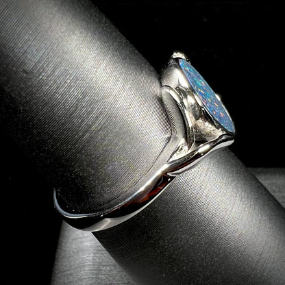 A silver leaf-style ring mounted with a multicolor black opal doublet.