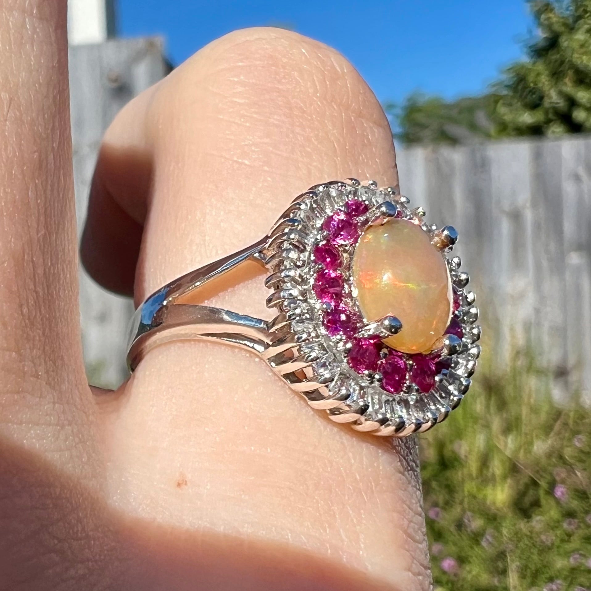 A sterling silver Ethiopian opal ring mounted with a halo of white CZs and another halo of synthetic pink sapphires.