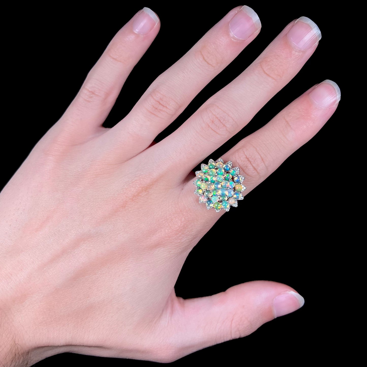 A sterling silver cluster flower ring mounted with 33 round Ethiopian fire opals.