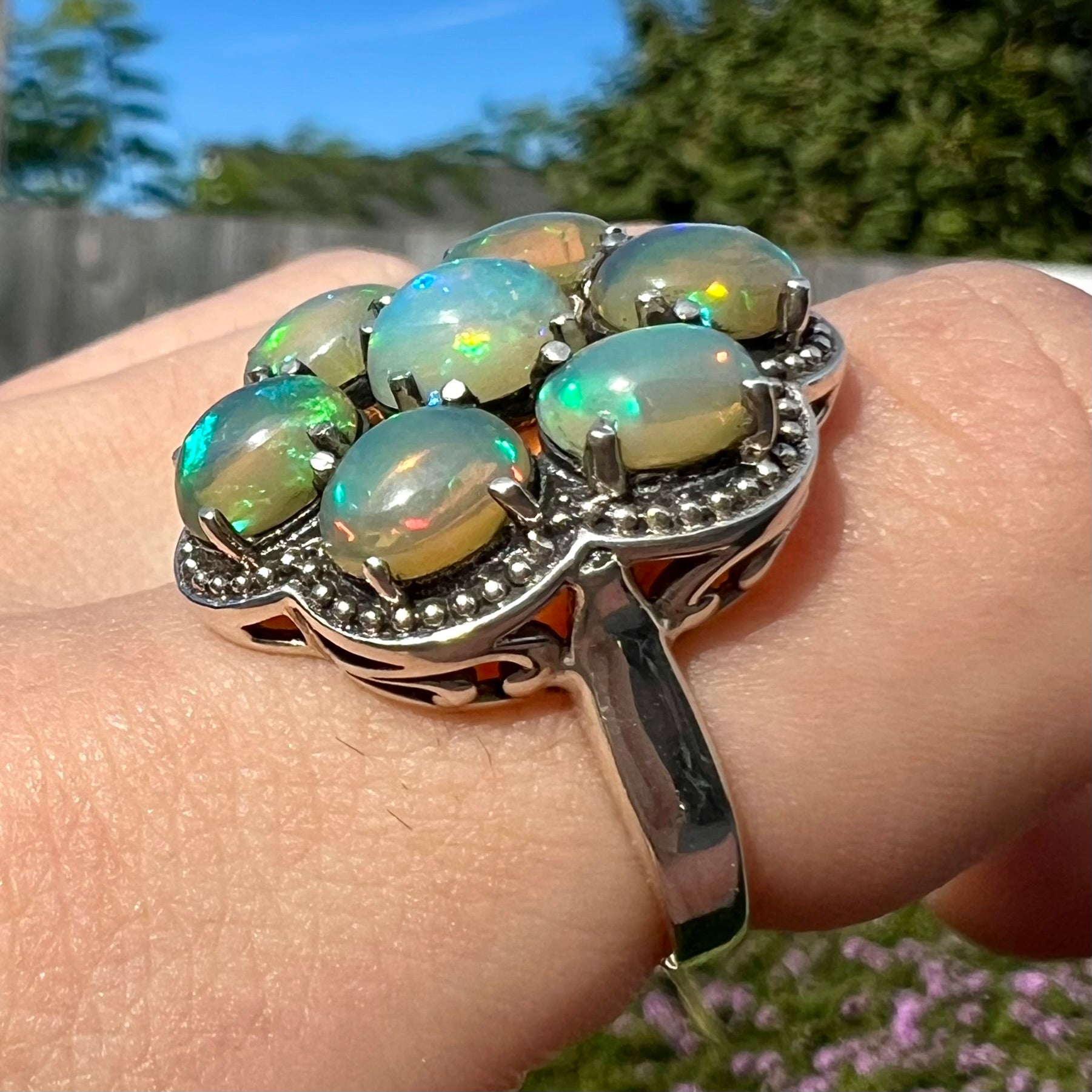 A sterling silver cluster ring prong-set with seven green Ethiopian fire opals.