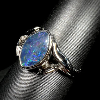 A sterling silver ring mounted with a marquise cut black opal doublet.  The opal has red fire.