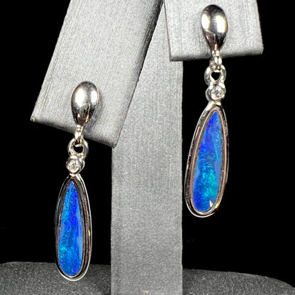 A pair of sterling silver dangle earrings mounted with pear shaped black opal doublets.