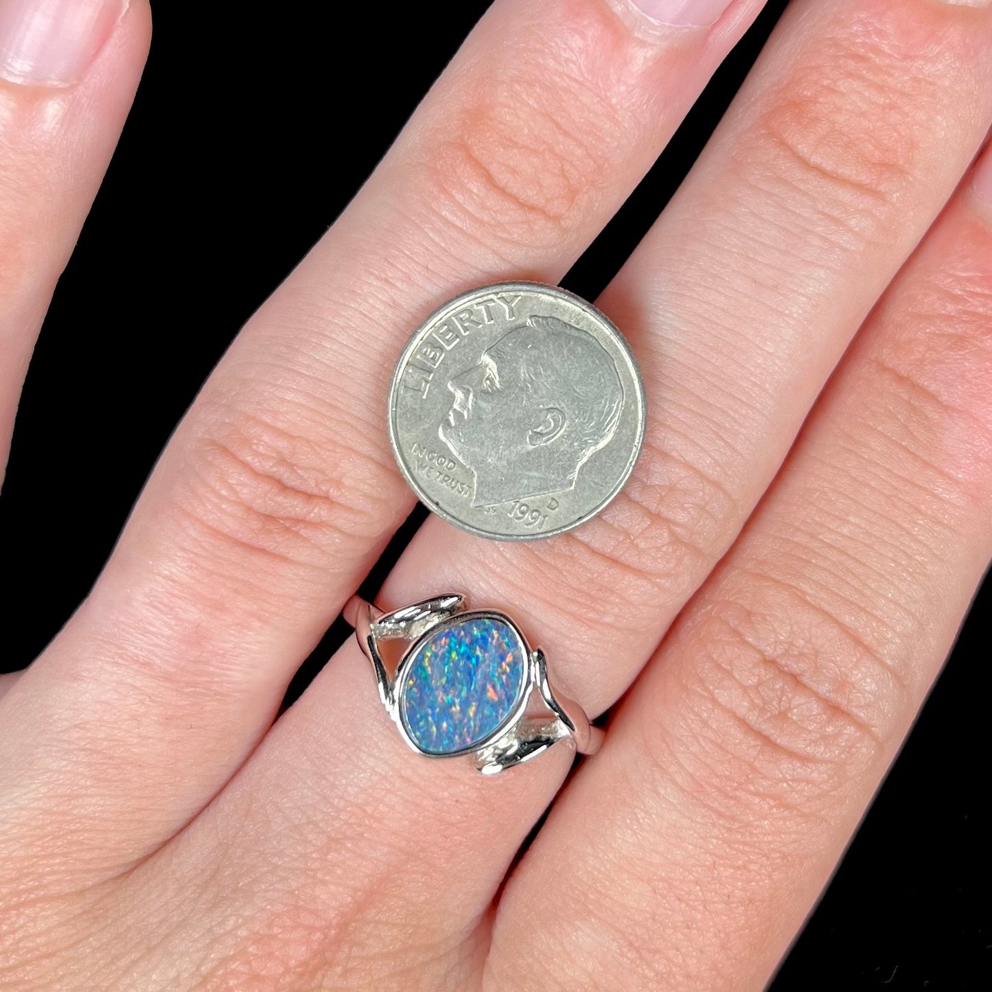 A silver leaf-style ring mounted with a multicolor black opal doublet.