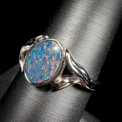 A silver leaf-style ring mounted with a multicolor black opal doublet.