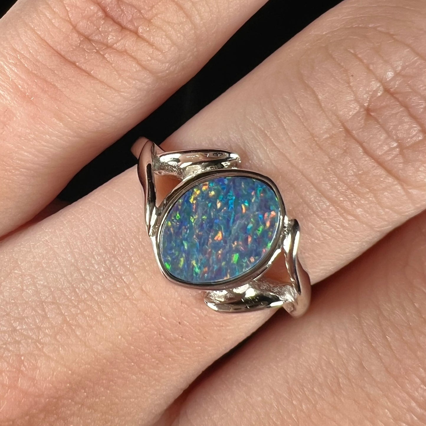 A silver leaf-style ring mounted with a multicolor black opal doublet.