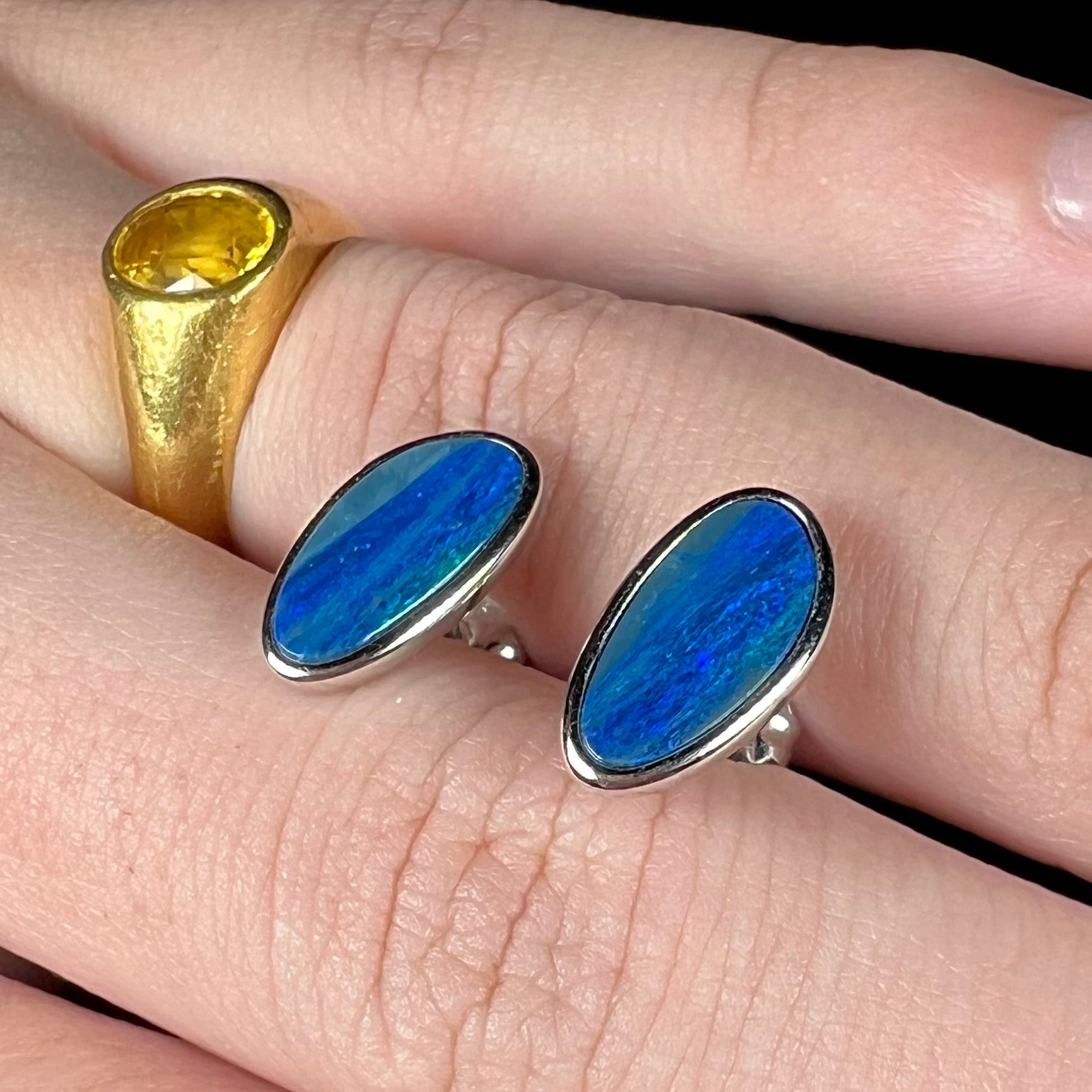 A pair of sterling silver opal doublet stud earrings.  The opals have a vivid blue color.