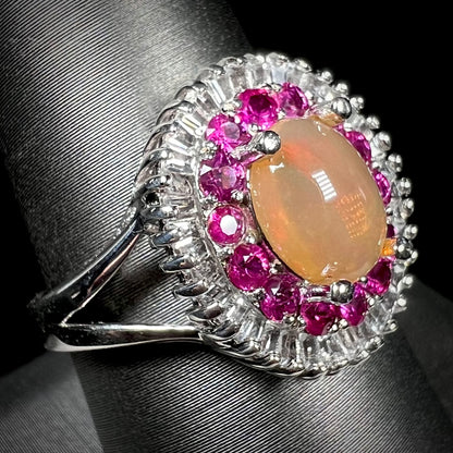 A sterling silver Ethiopian opal ring mounted with a halo of white CZs and another halo of synthetic pink sapphires.