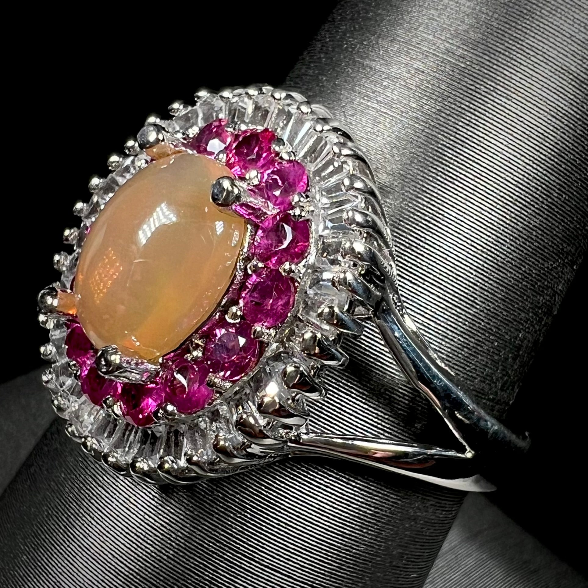 A sterling silver Ethiopian opal ring mounted with a halo of white CZs and another halo of synthetic pink sapphires.