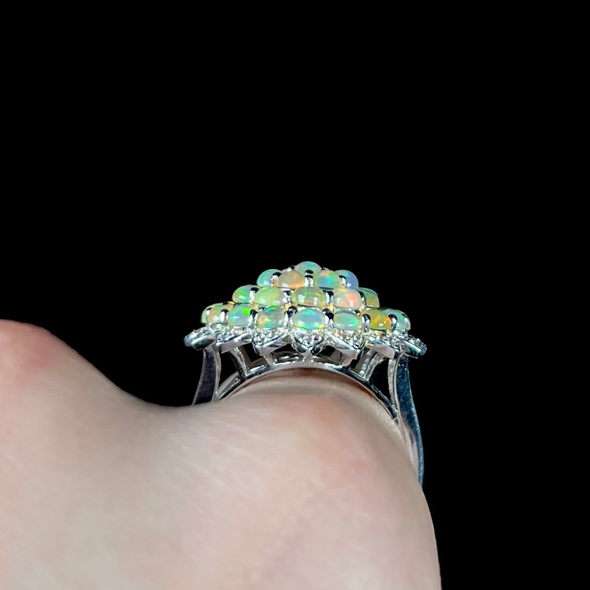 A sterling silver cluster flower ring mounted with 33 round Ethiopian fire opals.