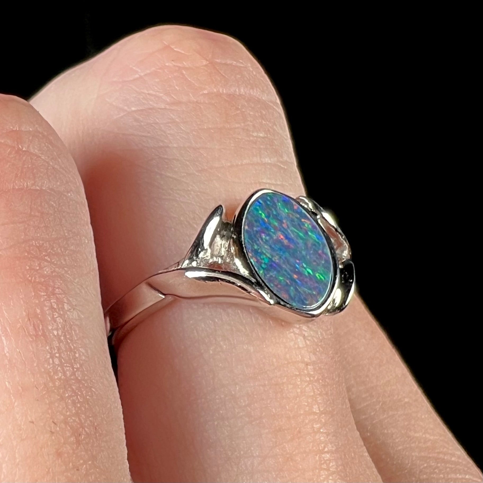 A silver leaf-style ring mounted with a multicolor black opal doublet.