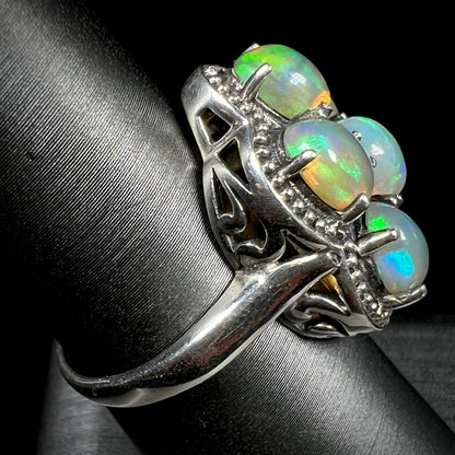 A sterling silver cluster ring prong-set with seven green Ethiopian fire opals.