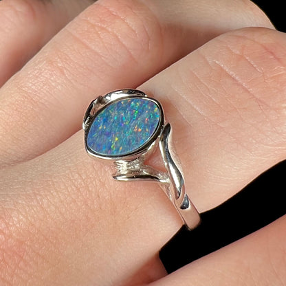 A silver leaf-style ring mounted with a multicolor black opal doublet.