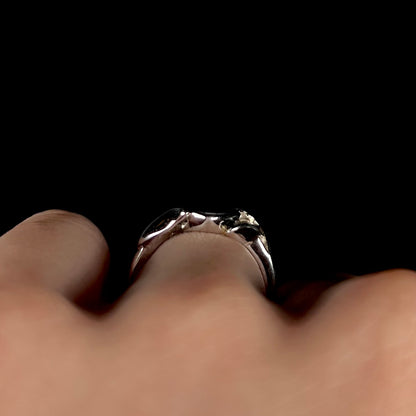 A sterling silver ring mounted with a marquise cut black opal doublet.  The opal has red fire.