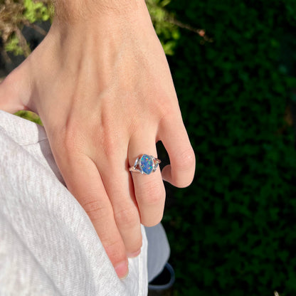 A sterling silver ring mounted with a marquise cut black opal doublet.  The opal has red fire.