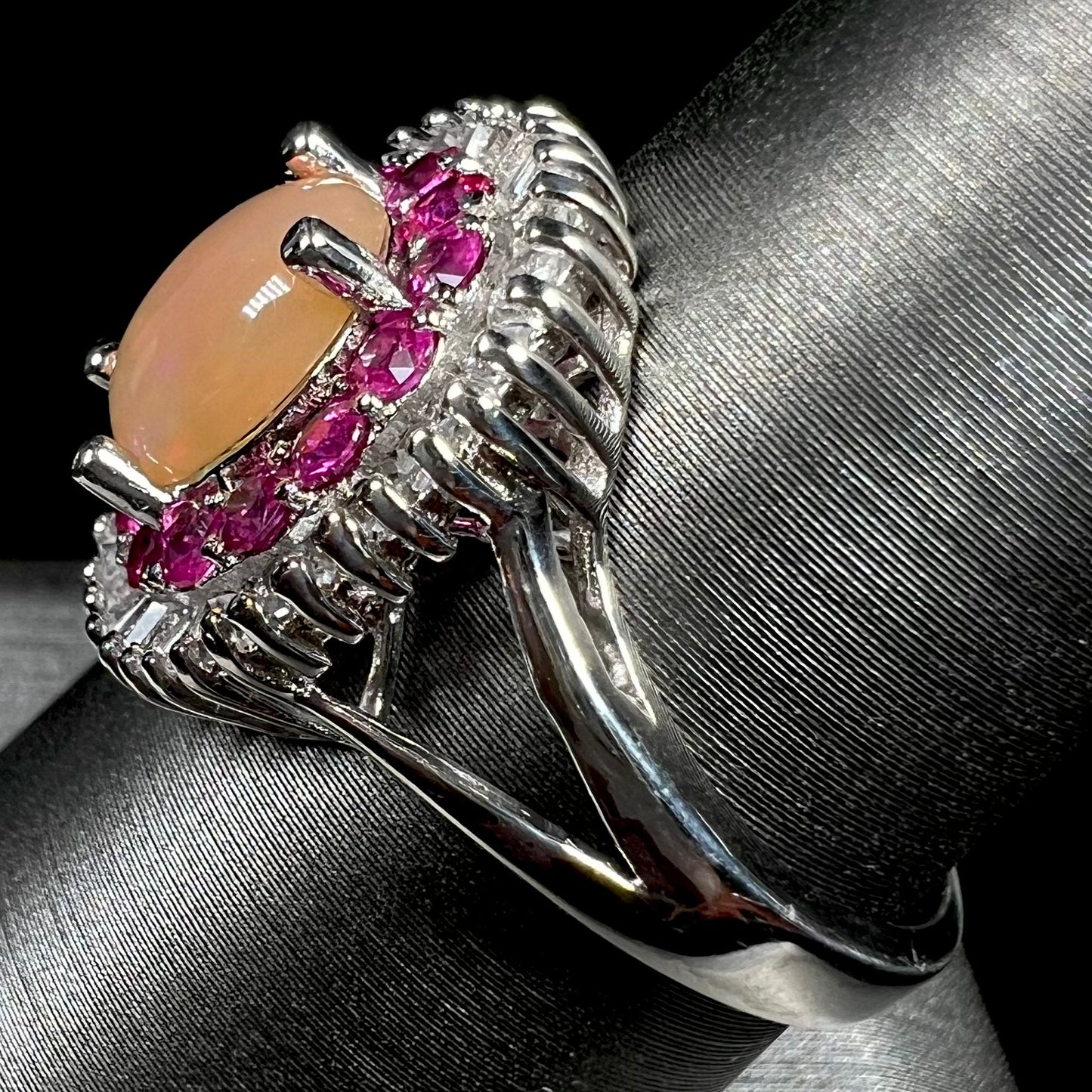 A sterling silver Ethiopian opal ring mounted with a halo of white CZs and another halo of synthetic pink sapphires.