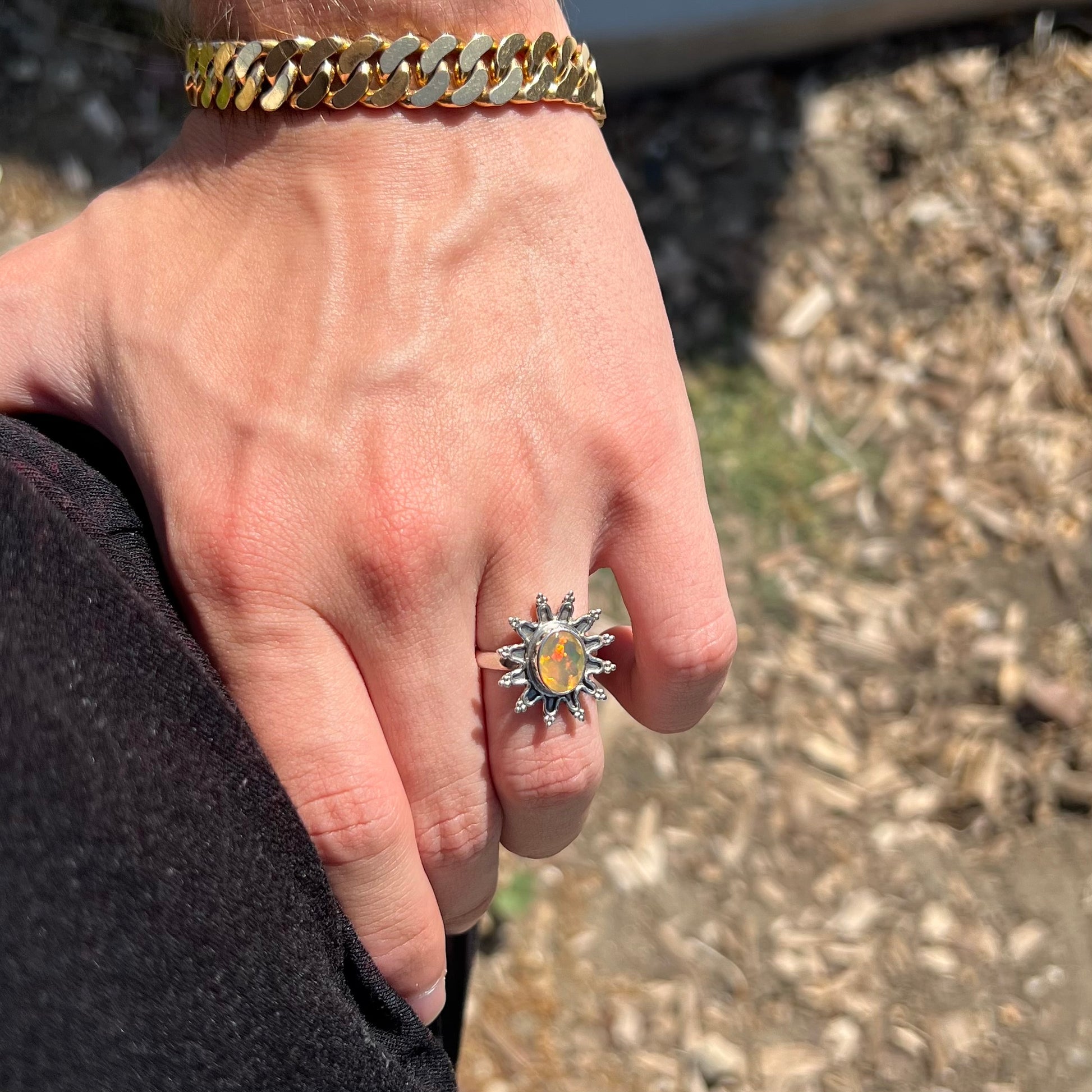 A sterling silver sunburst-style ring mounted with a faceted oval cut Ethiopian fire opal.